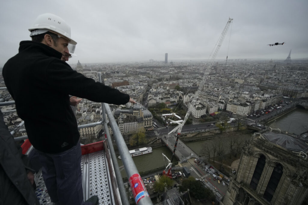 French President Emmanuel Macron watches Notre Dame cathedral from the top of the spire of the monument on Friday, 8th December, 2023 in Paris.