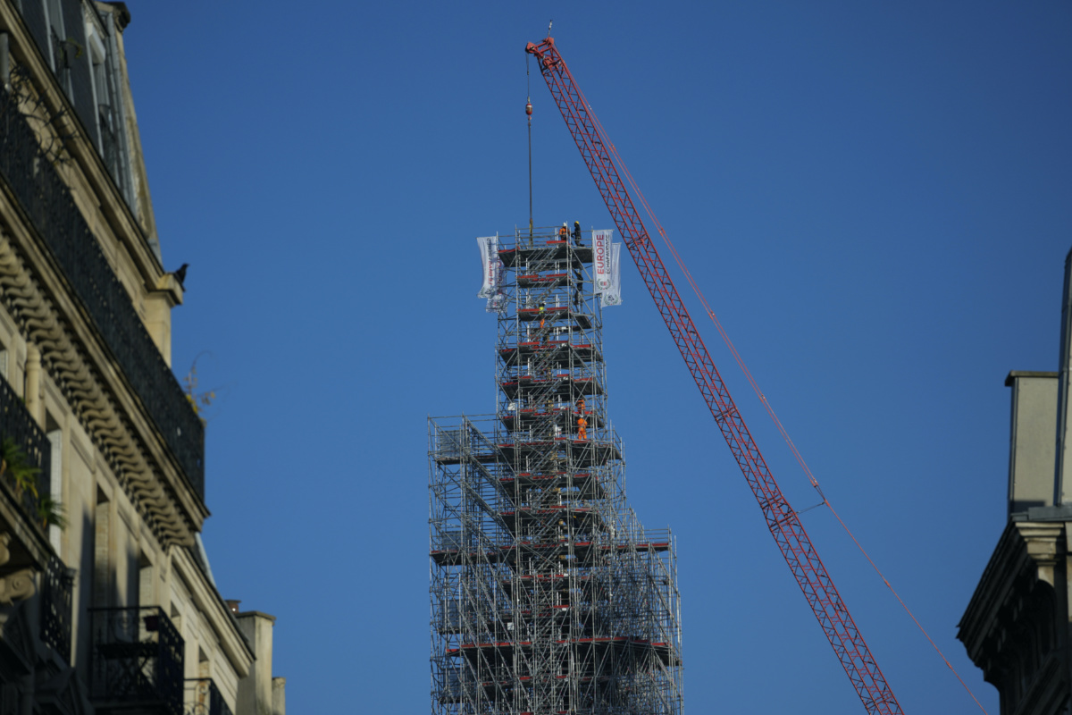 Workers stand on scaffolding by the spire of Notre-Dame de Paris cathedral on Wednesday, 6th December, 2023 in Paris.