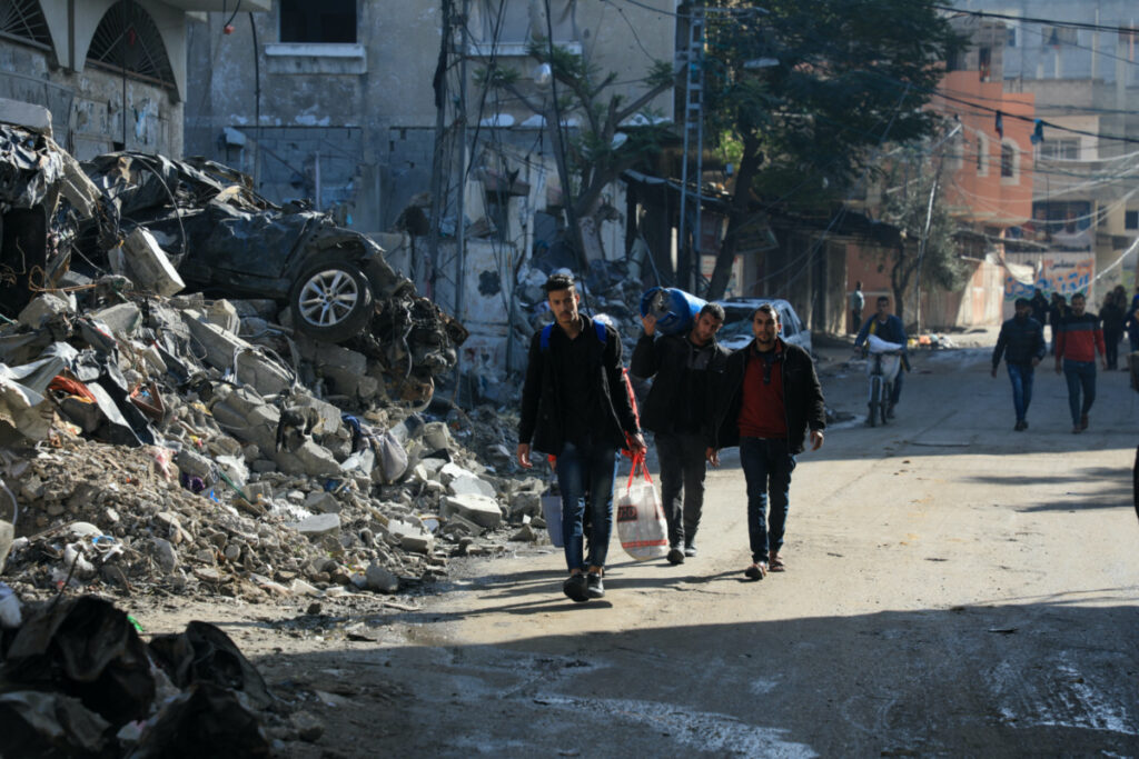 Palestinians carry belongings, as they flee their houses, after they were ordered by the Israeli army to evacuate the area, in Bureij in the central Gaza Strip on 26th December, 2023.