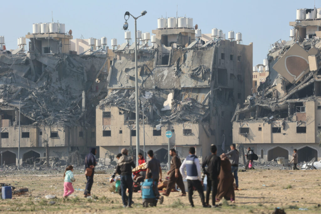 Building lie in ruin as Palestinians carry their belongings following Israeli strikes on residential buildings at the Qatari-funded Hamad City, amid the ongoing conflict between Israel and the Palestinian Islamist group Hamas, in Khan Younis in the southern Gaza Strip on 2nd December, 2023