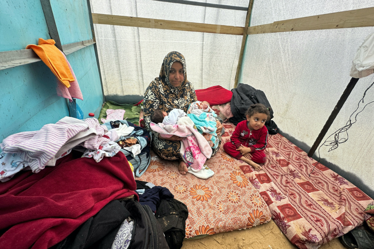 The grandmother of Salma and Alma Al-Jadba, twin Palestinian baby girls who were war born during the conflict between Israel and Hamas, holds them in a tent where they shelter with their displaced family who fled their house due to Israeli strikes, in Rafah in the southern Gaza Strip on 17th December, 2023.