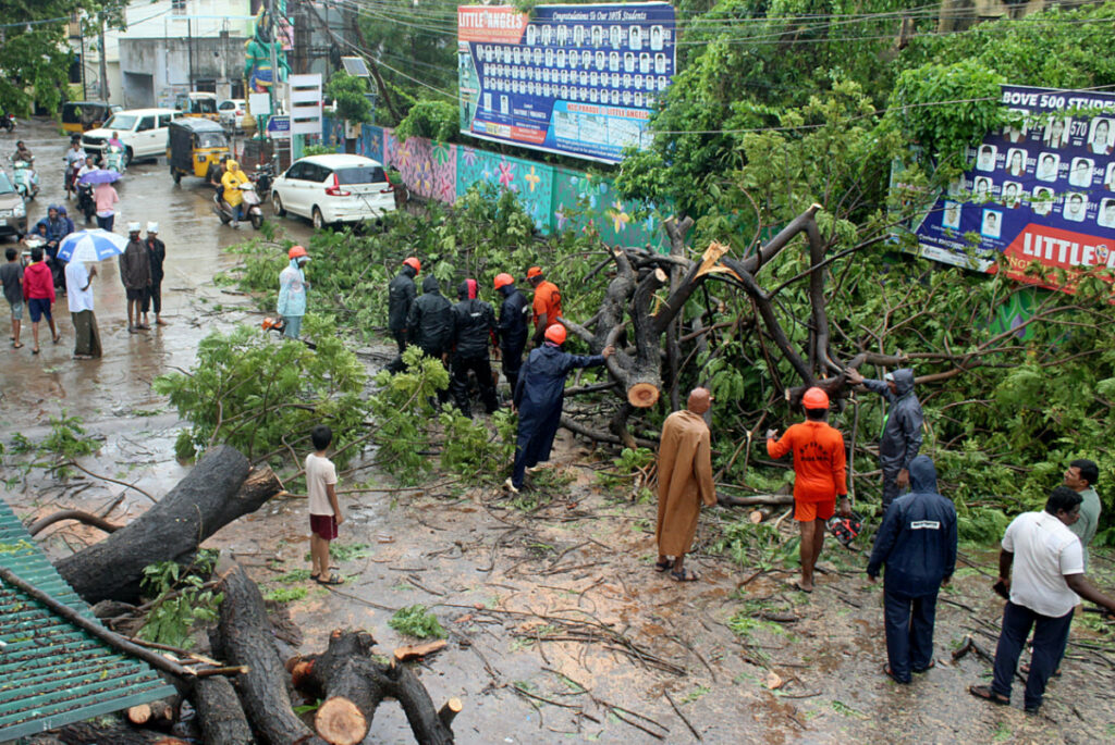 Members of Andhra Pradesh State Disaster Response Force cut the branches off a fallen tree after Cyclone Michaung made landfall, in Nellore district, in the southern state of Andhra Pradesh, India, on 5th December, 2023