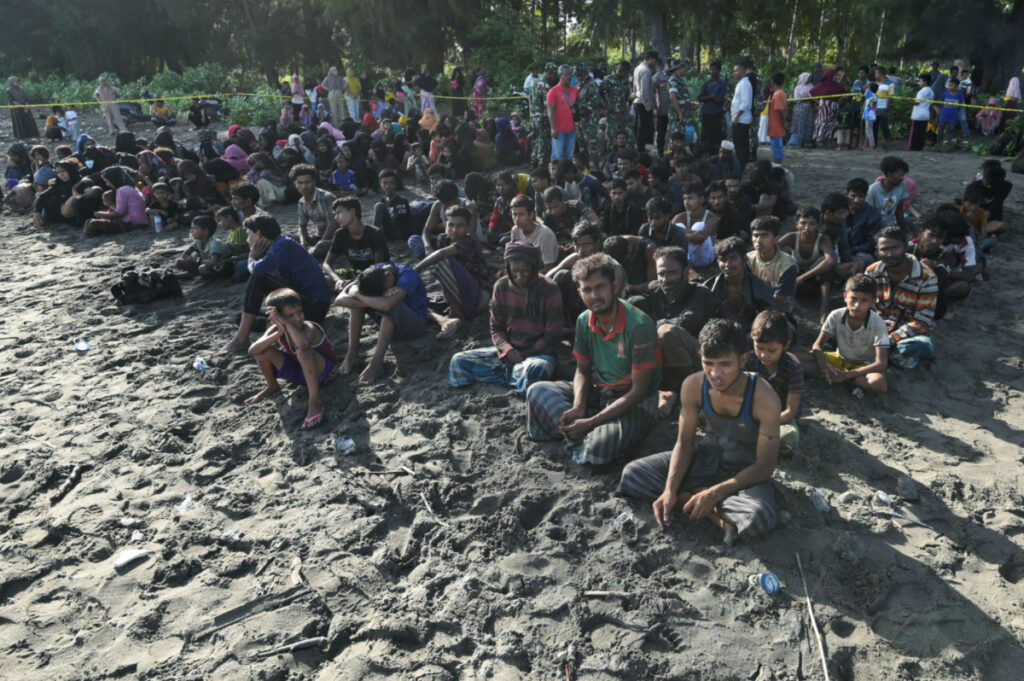 Rohingya Muslims rest on a beach after they land in Blang Raya, Pidie, Aceh province, Indonesia, on 10th December, 2023