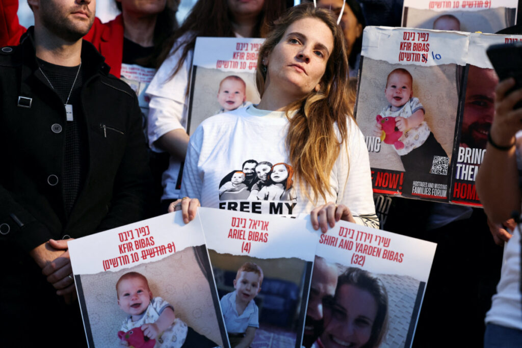 Protesters hold signs as they call for the immediate release of hostages, especially Shiri Bibas, 32, her husband Yarden Bibas, 34 and their children Kfir Bibas, 10 months, and Ariel, four, during the hostages-prisoners swap deal between Hamas and Israel, in Tel Aviv, Israel, on 28th November, 2023