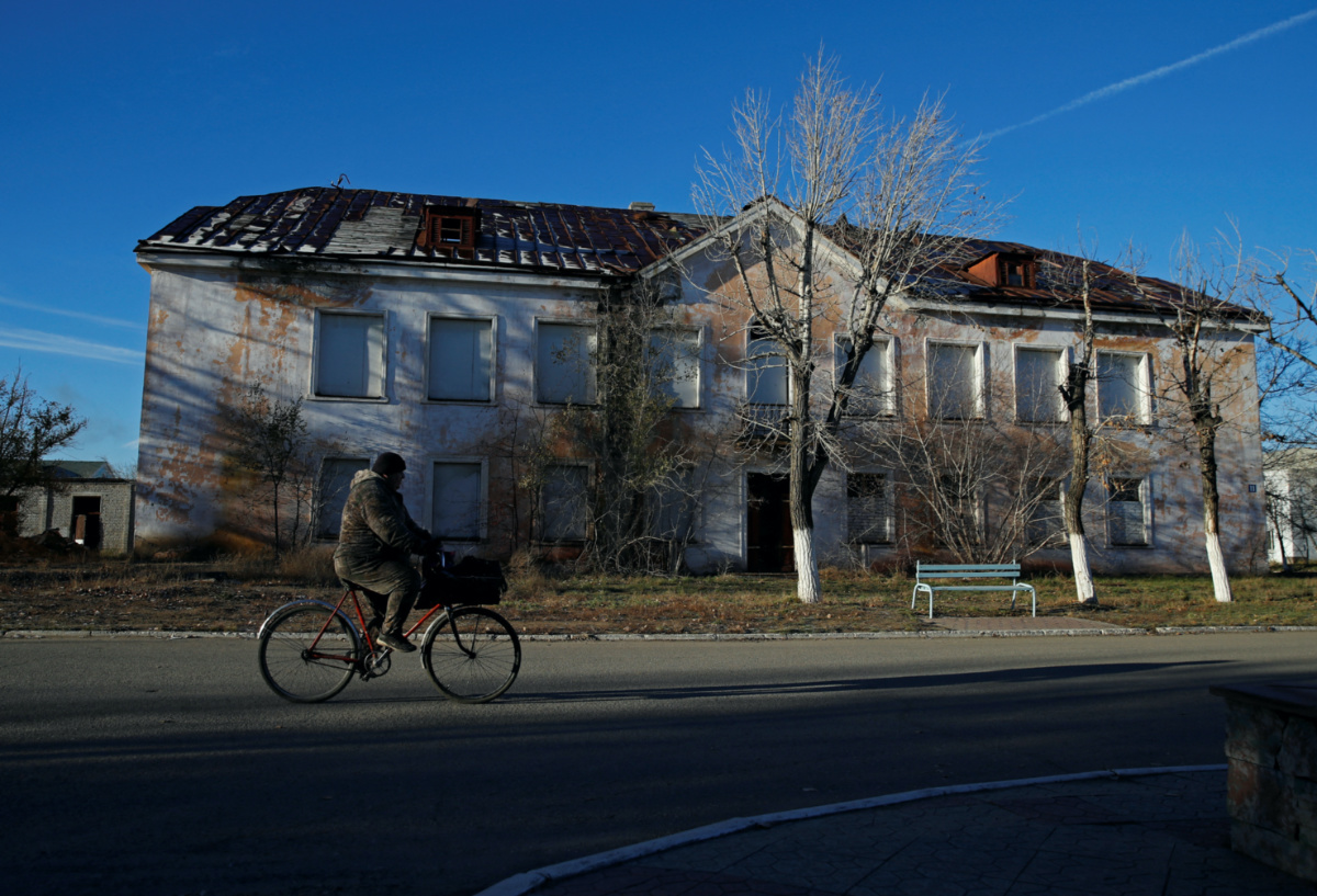 A man rides a bicycle past an abandoned building in the town of Kurchatov, which housed the command centre of the Semipalatinsk Test Site, one of the main locations for nuclear testing in the Soviet Union, in the Abai Region, Kazakhstan on 8th November, 2023