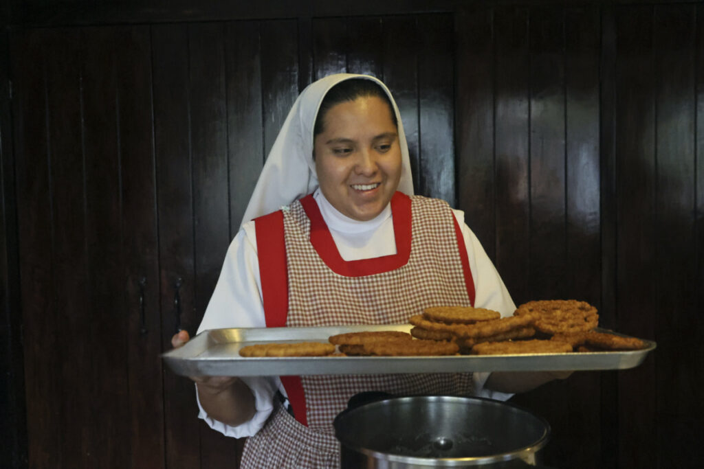 Nun Maria de Jesus Frayle, 24, holds a tray with fried Christmas figures at the Mothers Perpetual Adorers of the Blessed Sacrament convent in Mexico City, Thursday, on 7th December, 2023.
