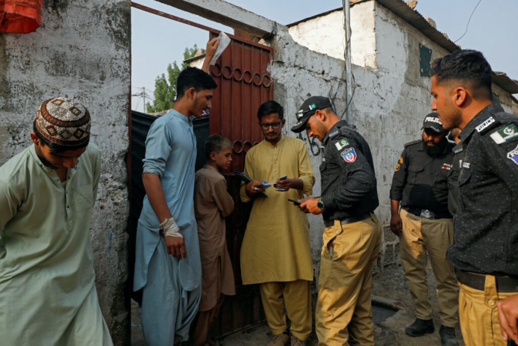 Police officers, along with workers from the National Database and Registration Authority, check the identity cards of Afghan citizens during a door-to-door search and verification drive for undocumented Afghan nationals, in an Afghan Camp on the outskirts of Karachi, Pakistan, on 21st November, 2023