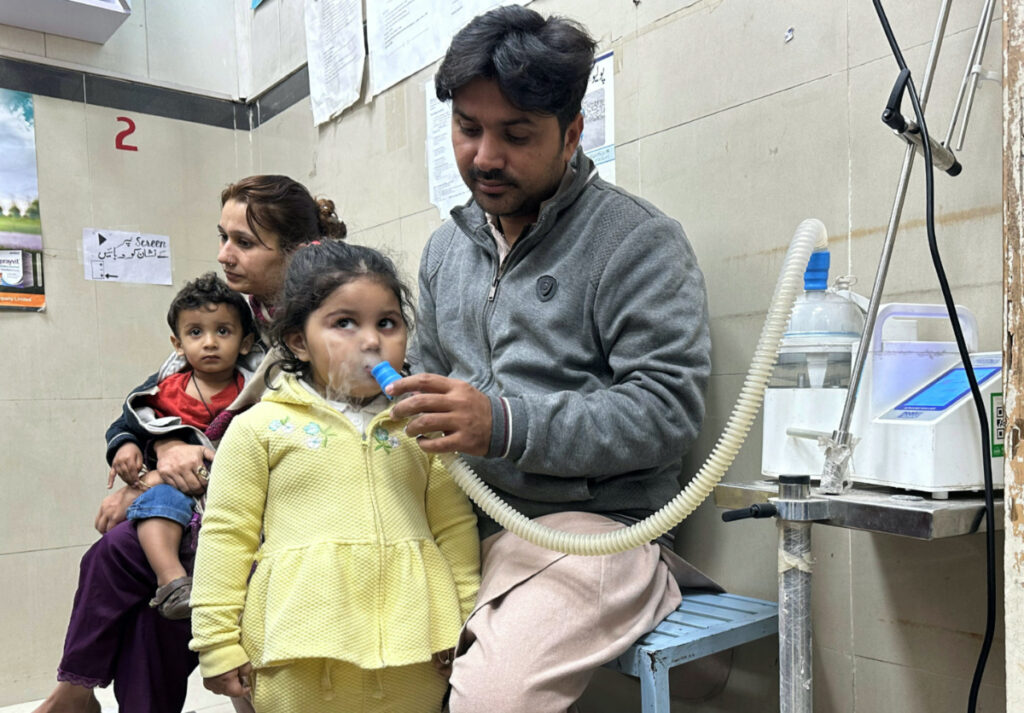 Mohamad Qadeer holds up a nebuliser device to the face of his daughter, Rameen, three, who is suffering from a chest infection amidst soaring air pollution, in the emergency room of Sir Ganga Ram hospital in Lahore, Pakistan, on 4th December, 2023