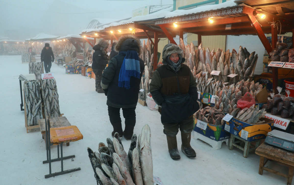Vendor Yegor Dyachkovsky stands next to deep-frozen fish at an open-air market on a frosty day in Yakutsk, Russia, on 5th December, 2023
