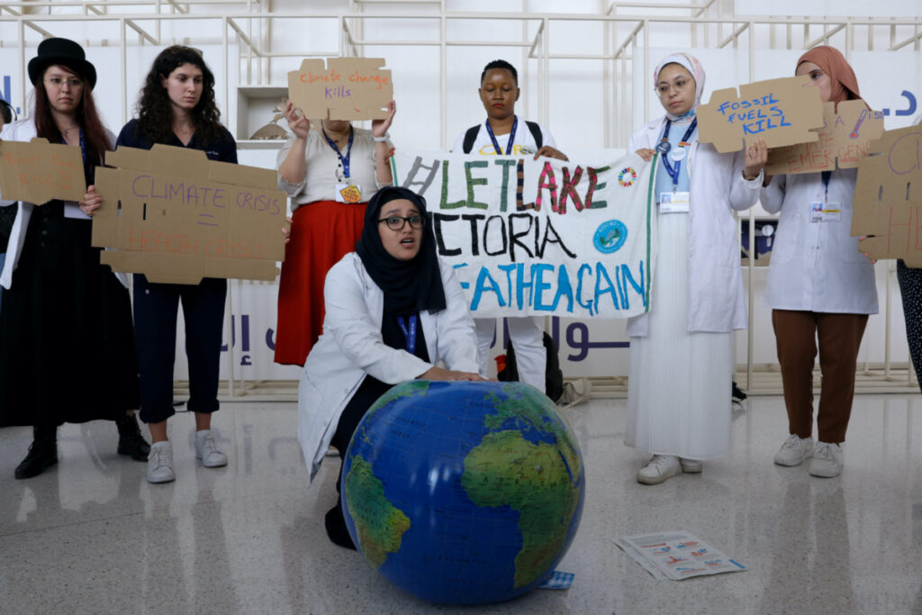 Members of the International Federation of Medical Students Associations hold placards during a protest demanding an end to fossil fuels at COP28 World Climate Summit, in Dubai, United Arab Emirates, on 3rd December, 2023.