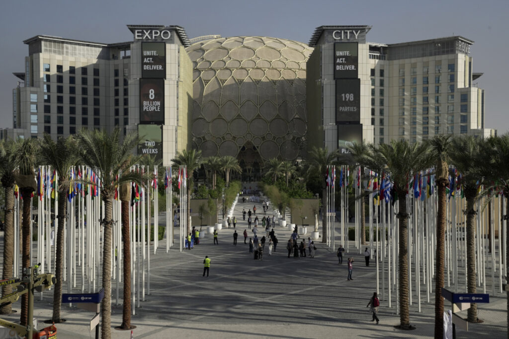People walk through the venue for the COP28 UN Climate Summit, with the Al Wasl Dome in the background, at Expo City, on 29th November, 2023, in Dubai, United Arab Emirates.