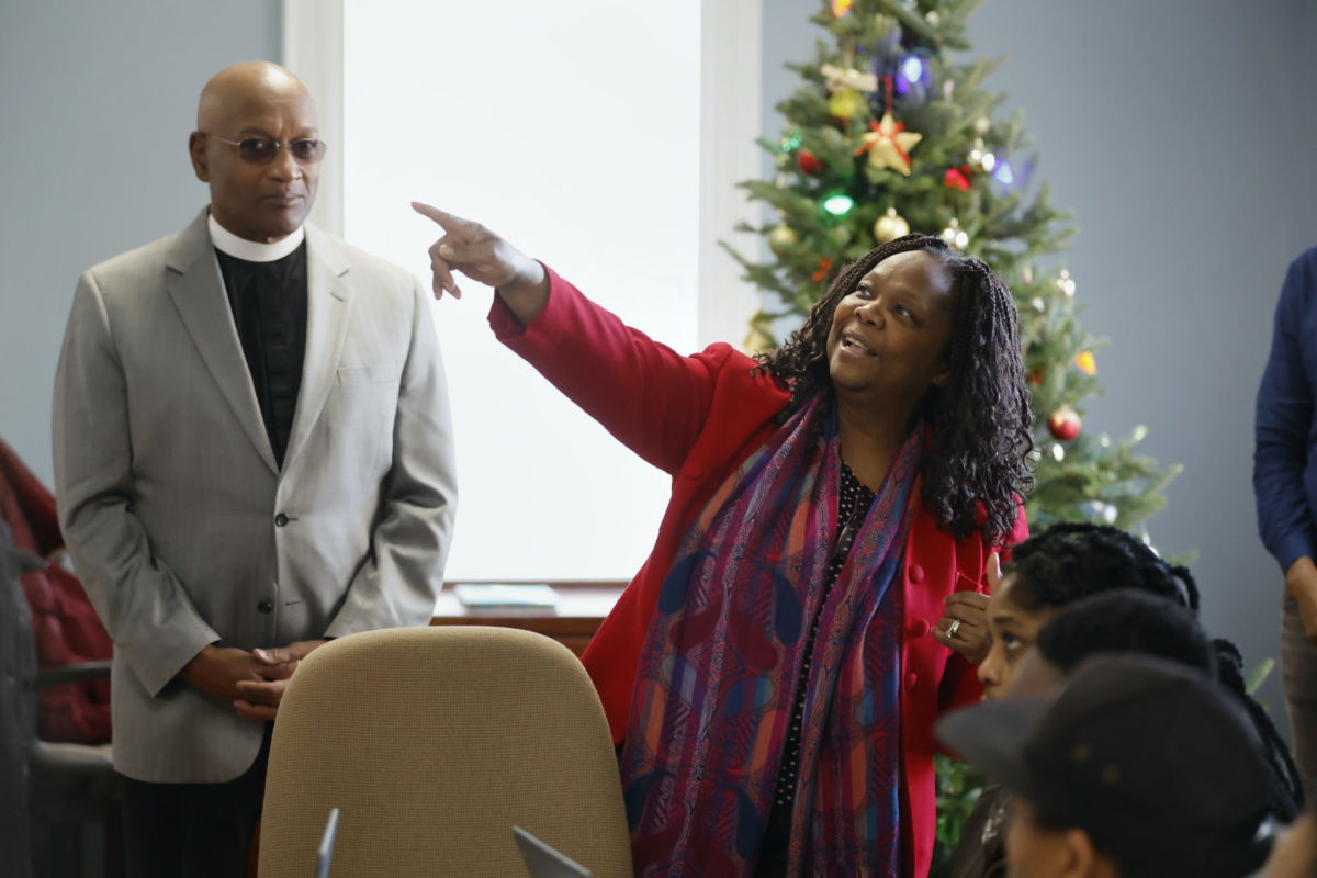 Geralde Gabeau, executive director of the Immigrant Family Services Institute in Boston, speaks with Haitian immigrants as Pastor Ray Hammond, left, looks on, on Friday, 22nd December 2023