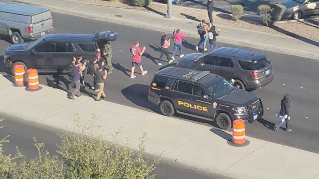 People leave campus with raised hands following reports of a shooting at the University of Nevada, in the campus of Las Vegas, US