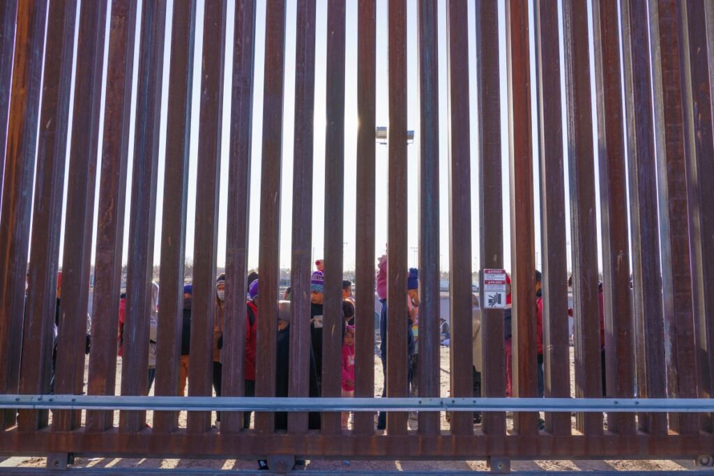 Migrants from Nicaragua and Ecuador stand by a door on the border wall waiting to be picked up by United States Border Patrol in El Paso, Texas, US, on 4th January, 2023
