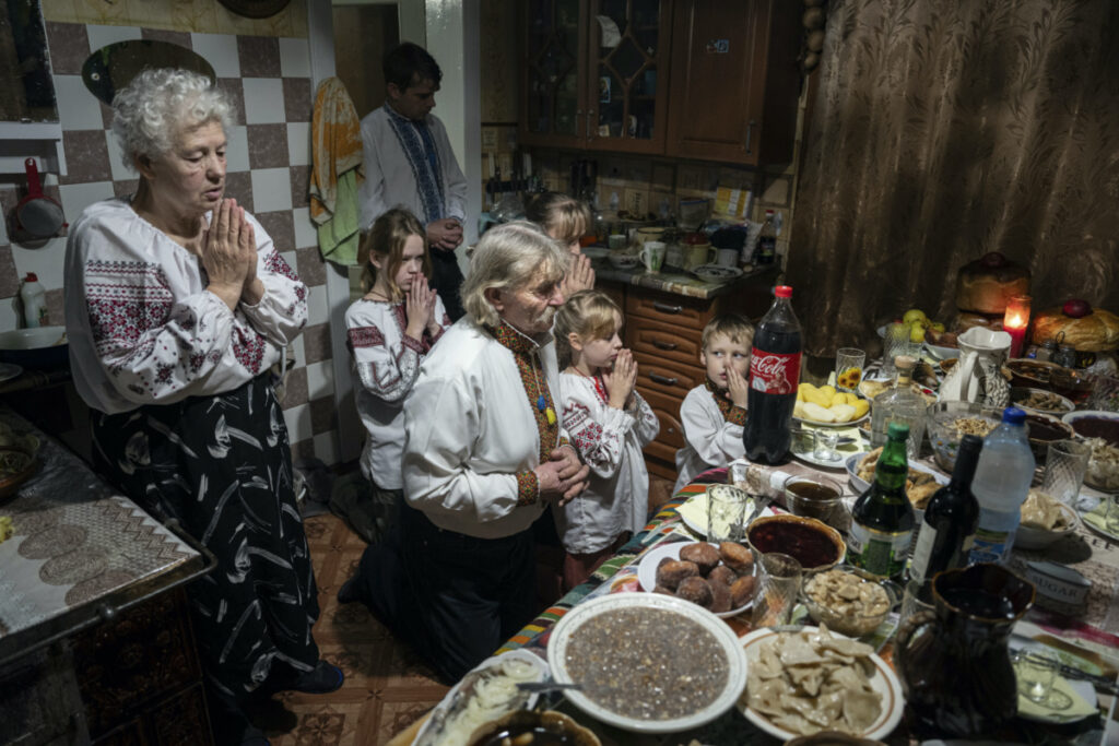 The Zelenchuk family prays before a Christmas dinner in Kryvorivnia village, Ukraine, on Sunday, 24th December, 2023.