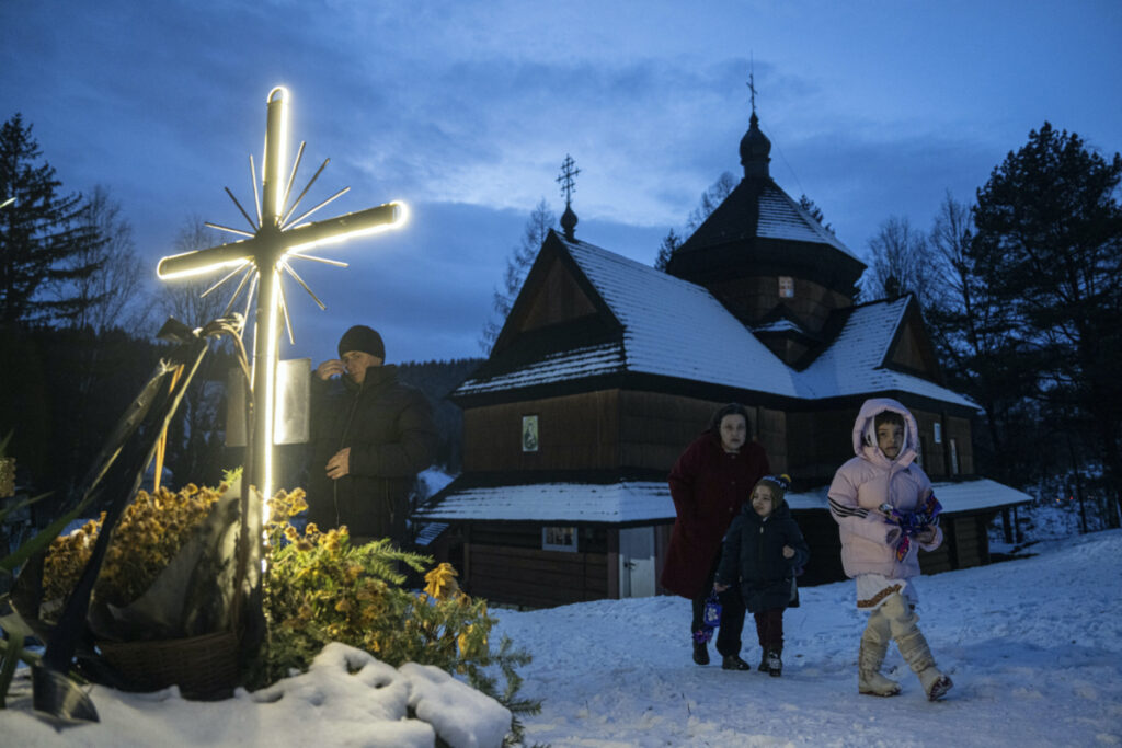 A woman with her children walk after church Christmas service in Kryvorivnia village, Ukraine, on Sunday, 24th December, 2023.