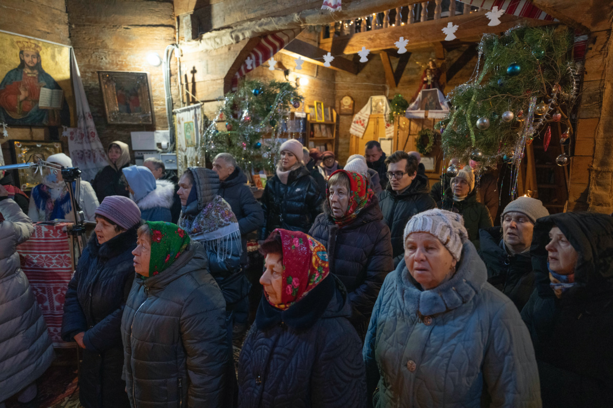 People pray as they attend Christmas service in a church in the village of Pirogovo outside capital Kyiv, Ukraine, on Monday, 25th December, 2023.