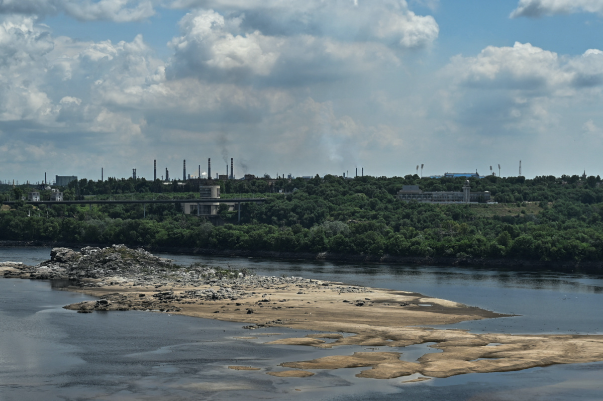 A view shows the city skyline and a rocky island in the Dnipro river which became visible again after water level sharply dropped following Kakhovka dam destruction, amid Russia's attack on Ukraine, in Zaporizhzhia, Ukraine on 25th June, 2023