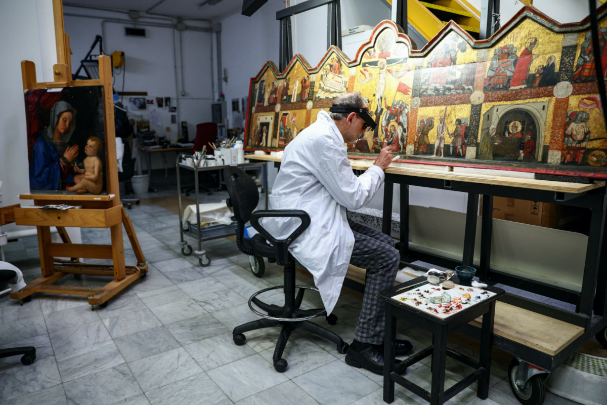 Restorer Marco Pratelli works on a painting at the "painting and wood materials restoration laboratory" inside the Vatican Museums, at the Vatican, on 11th December, 2023