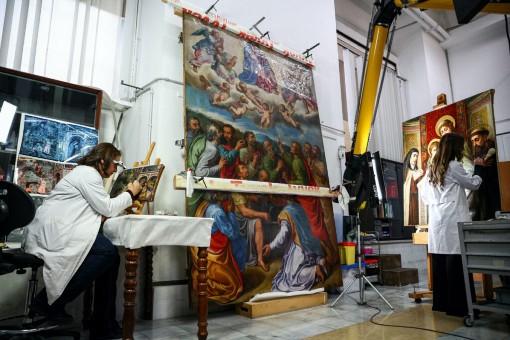 Restorers Chiara Notarsfefano and Caterina Manisco work on paintings at the "painting and wood materials restoration laboratory" inside the Vatican Museums, at the Vatican, on 11th December, 2023.