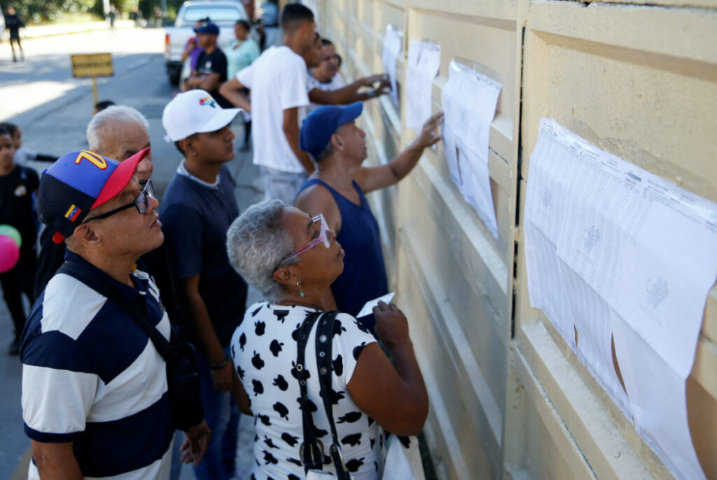 People look at the electoral list on the day of an electoral referendum over Venezuela's rights to the potentially oil-rich region of Esequiba, which has long been the subject of a border dispute between Venezuela and Guyana, in Caracas, Venezuela, on 3rd December, 2023
