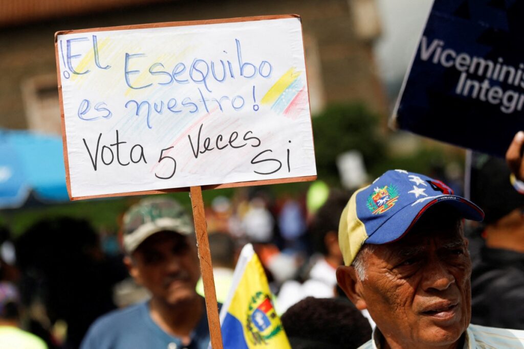 A government supporter holds a sign that reads: “The Essequibo is ours, vote YES 5 times” while participating in an event to collect signatures in support of a referendum over Venezuela's rights to the potentially oil-rich region of Esequiba in Guyana, in Caracas, Venezuela on 15th November, 2023.