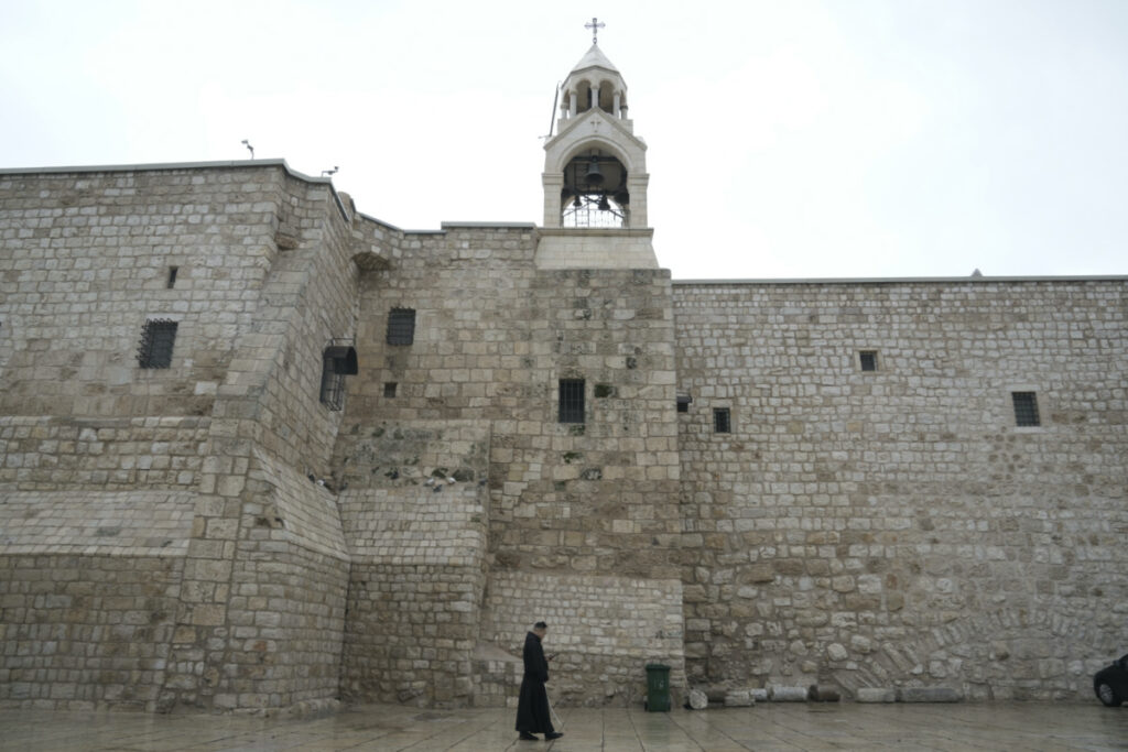 A priest walks by the Church of the Nativity, traditionally believed to be the birthplace of Jesus, on Christmas Eve, in the West Bank city of Bethlehem, on Sunday, 24th December, 2023.