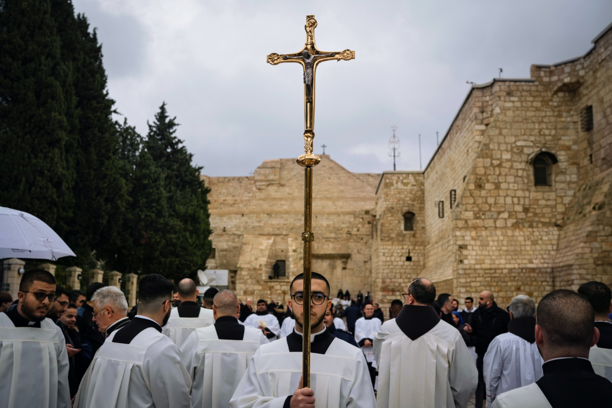 Catholic clergy walk in procession next to the Church of the Nativity, traditionally believed to be the birthplace of Jesus, on Christmas Eve, in the West Bank city of Bethlehem, on Sunday, 24th December, 2023.