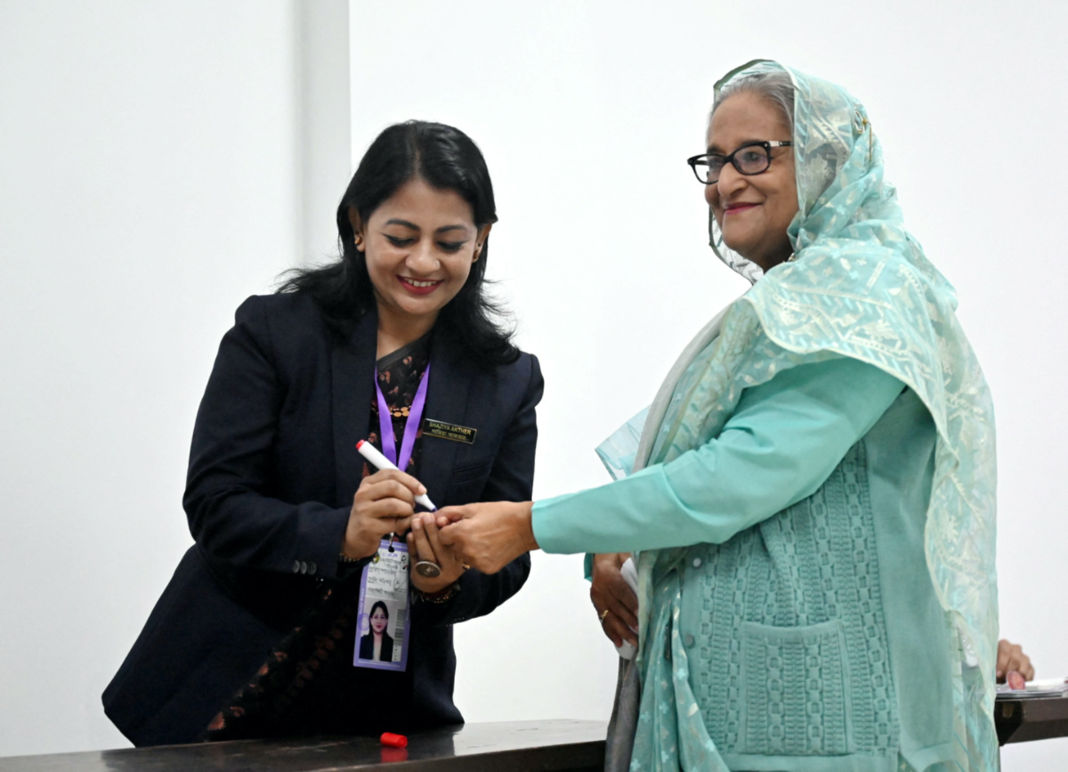 An officer puts an ink mark on the thumb of Sheikh Hasina, Prime Minister of Bangladesh and Chairperson of Bangladesh Awami League, at the Dhaka City College center during the 12th general election in Dhaka, Bangladesh, on 7th January, 2024