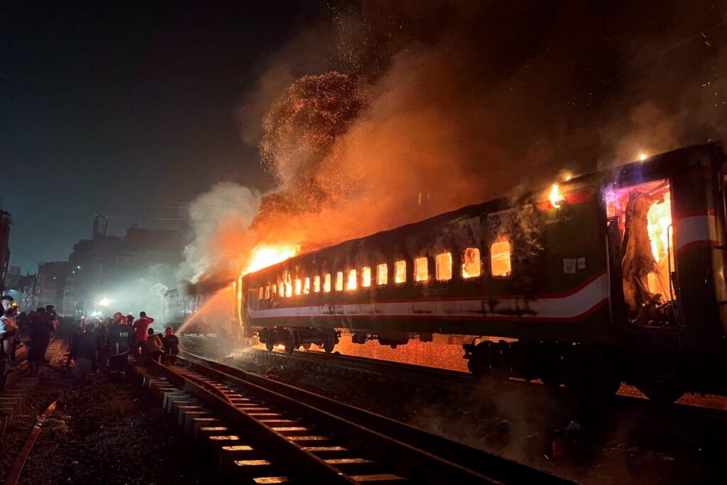 Firefighters try to extinguish a fire caught on a passenger train, ahead of the general election in Dhaka, Bangladesh, on 5th January, 2024