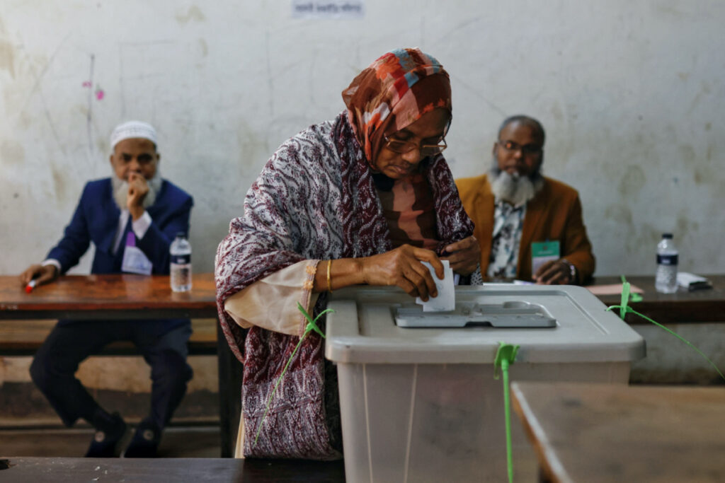 An elderly woman puts ballot paper inside a ballot box after casting her vote in the morning during the 12th general election in Dhaka, Bangladesh, on 7th January, 2024