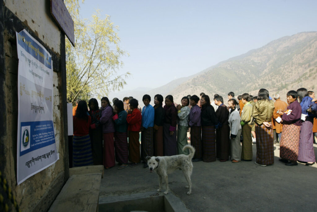 Bhutanese voters stand in a queue outside a polling station to cast their ballot in Thimpu on 24th March, 2008.