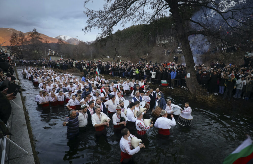 Men play bagpipes and drums as they wade into the cold Tundzha River to celebrate Epiphany, in the town of Kalofer, Bulgaria, on Saturday, 6th January, 2024