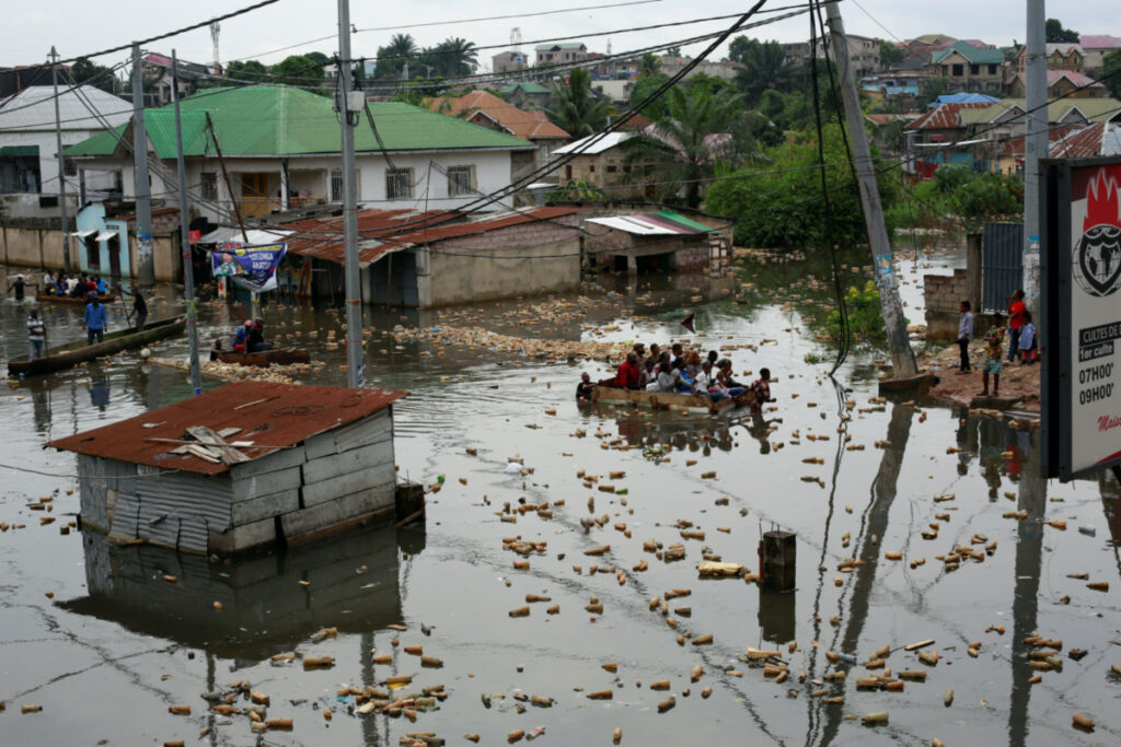 People use a makeshift boat to move after the Congo River rises to its highest level, causing flooding. Kinshasa, Democratic Republic of Congo, on 10th January, 2024