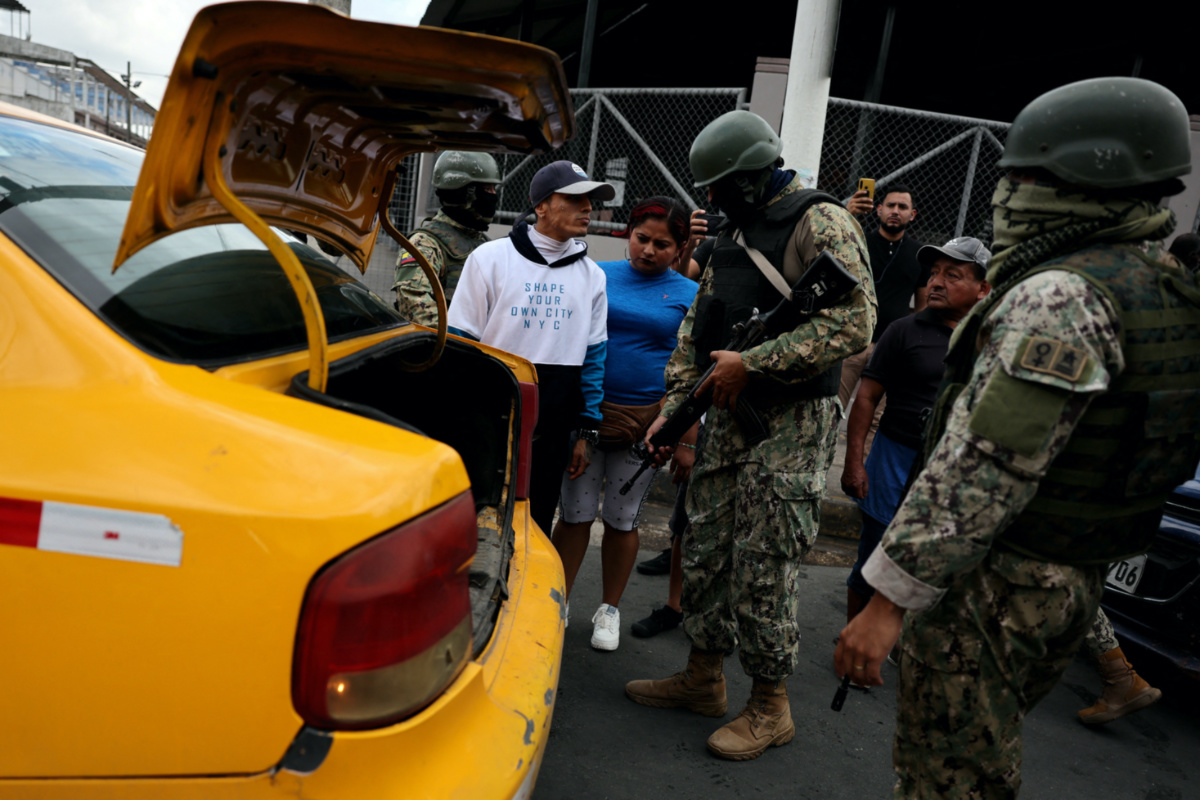 Armed soldiers prepare to inspect a car while patrolling in a commercial area, in the aftermath of a wave a violence that saw the storming of a TV station on-air and explosions around the nation, in Guayaquil, Ecuador, on 11th January, 2024.