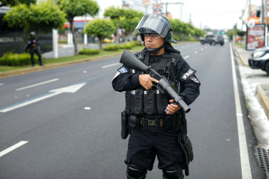 A police officer stands guard at a protest to demand help for the release of people detained during the state of emergency decreed by the government to curb gang violence, ahead of the Miss Universe gala to be held in San Salvador, El Salvador on 18th November, 2023.