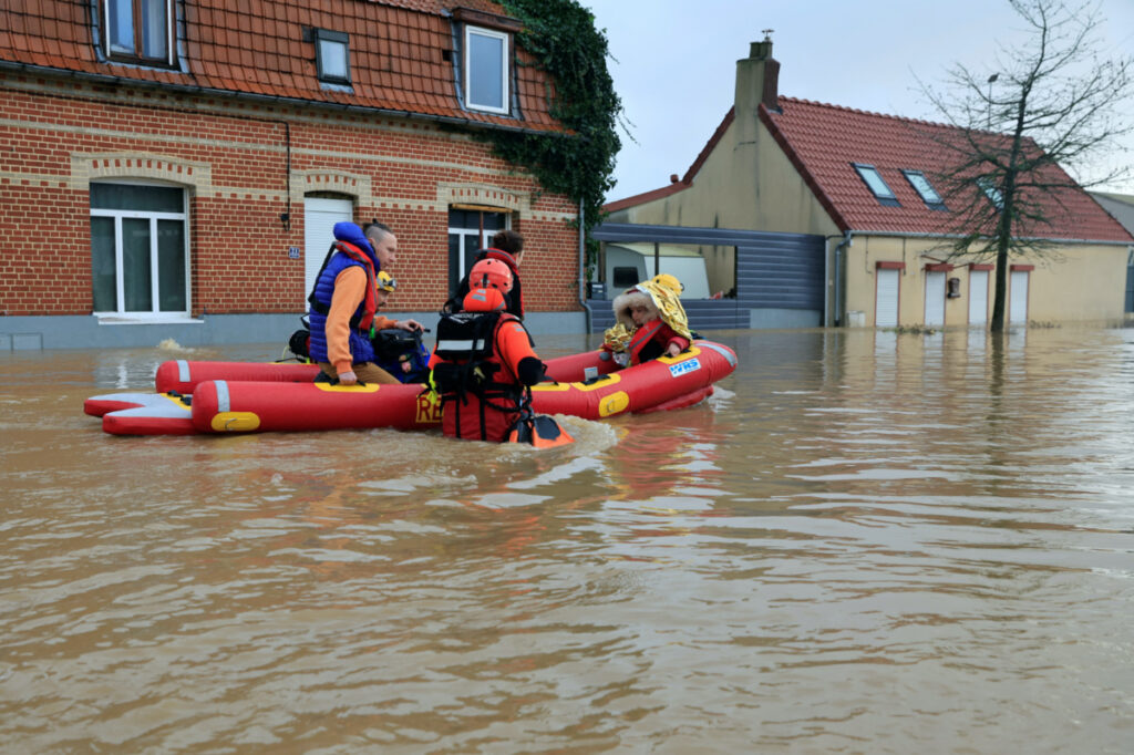 Members of French Civil Security rescue team evacuate local residents by boat as the Aa River overflows in Arques near Saint-Omer, after heavy rain caused flooding in northern France, on 3rd January, 2024