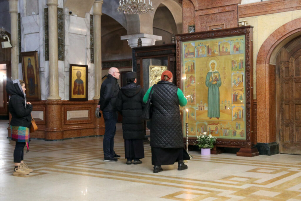People stand in front of an icon, an element of which depicts Soviet leader Joseph Stalin being blessed by Russian Orthodox saint Matrona of Moscow, and that was recently defaced with paint in an act of protest amid controversy over the icon’s apparent honouring of Stalin, at the Holy Trinity Cathedral in Tbilisi, Georgia, on 10th January, 2024