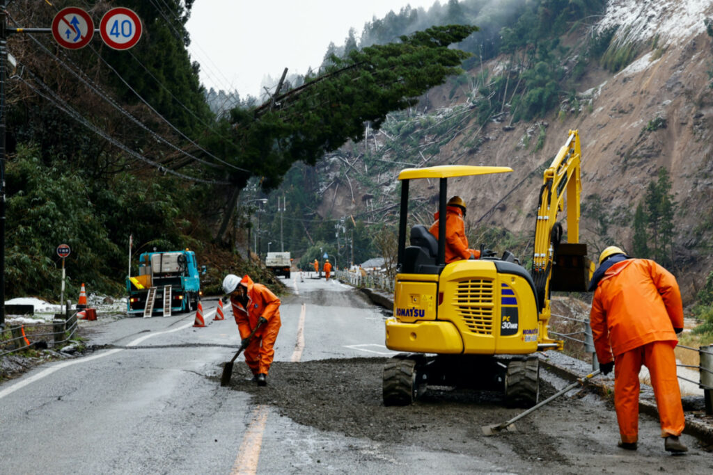 Workers repair a damaged road, in the aftermath of an earthquake, in Wajima, Ishikawa Prefecture, Japan, on 7th January, 2024.