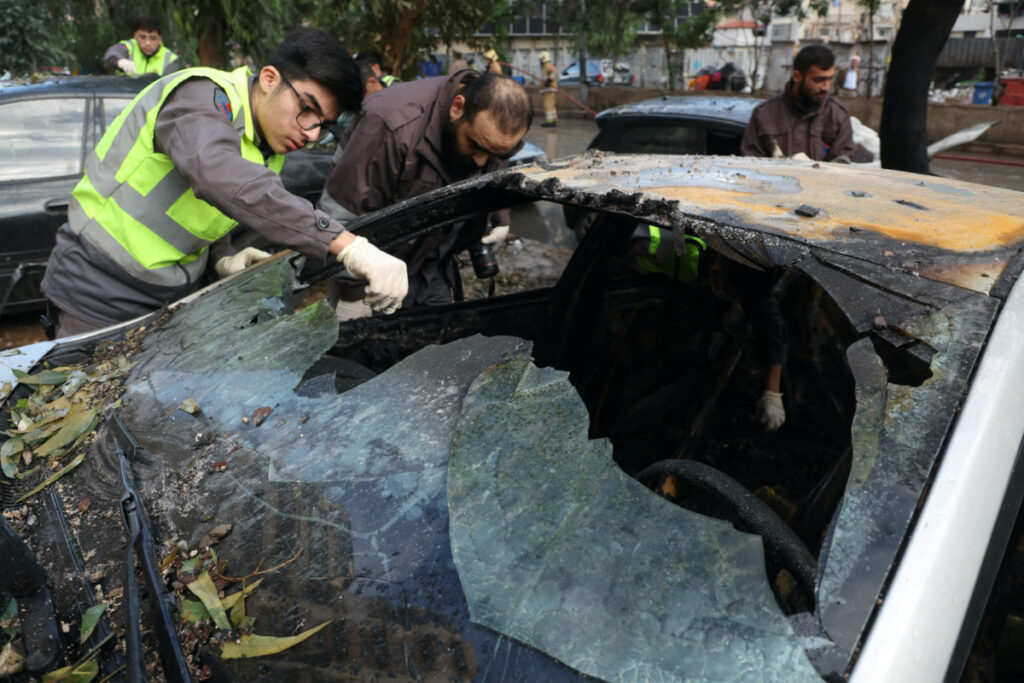 Hezbollah affiliated civil defence member checks a damaged car in the aftermath of what security sources said was an Israeli drone strike in Beirut's southern suburbs of Dahiyeh, Lebanon on 3rd January, 2024