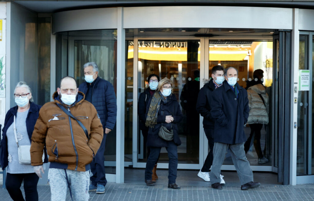 People wearing protective masks walk outside the Germans Trias i Pujol Hospital in Badalona, Spain, on 8th January, 2024