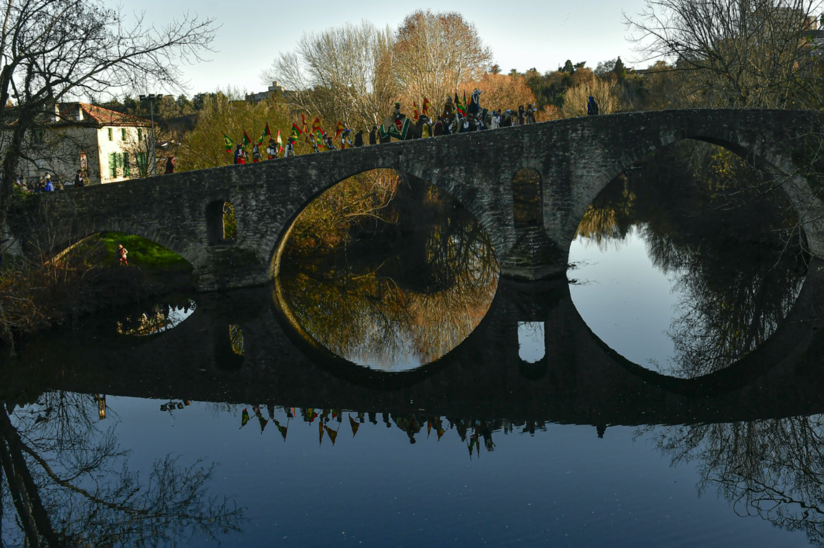 Three kings of The Cabalgata Los Reyes Magos are reflected in the waters of the Arga River as they cross the ancient Magdalena bridge before to entrance in the old city during the cavalcade the day before Epiphany, in Pamplona, northern Spain, on Thursday, 5th January, 2023