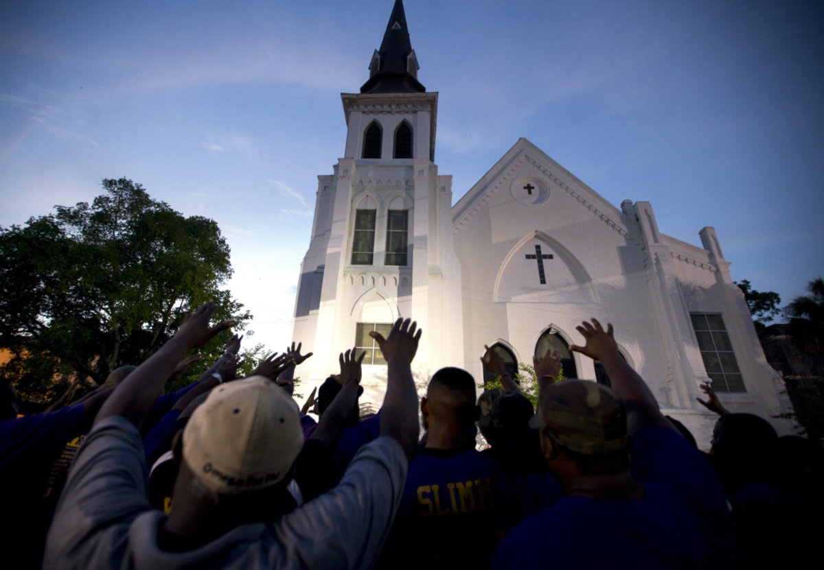 The men of Omega Psi Phi Fraternity Inc lead a crowd of people in prayer outside the Emanuel AME Church, on Friday, 19th June, 2015, after a memorial in Charleston, South Carolina. 