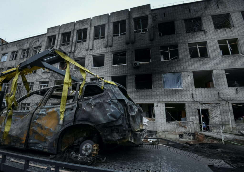 Communal workers prepare a damaged car to be towed near a residential building damaged during a Russian drone strike, amid Russia's attack on Ukraine, in Dnipro, Ukraine, on 7th January, 2024