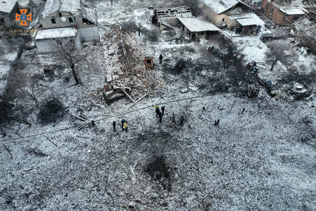 People stand next to a destroyed residential house and a crater at the site of a Russian missile strike, amid Russia's attack on Ukraine, in Dnipropetrovsk Region, Ukraine, on 8th January, 2024