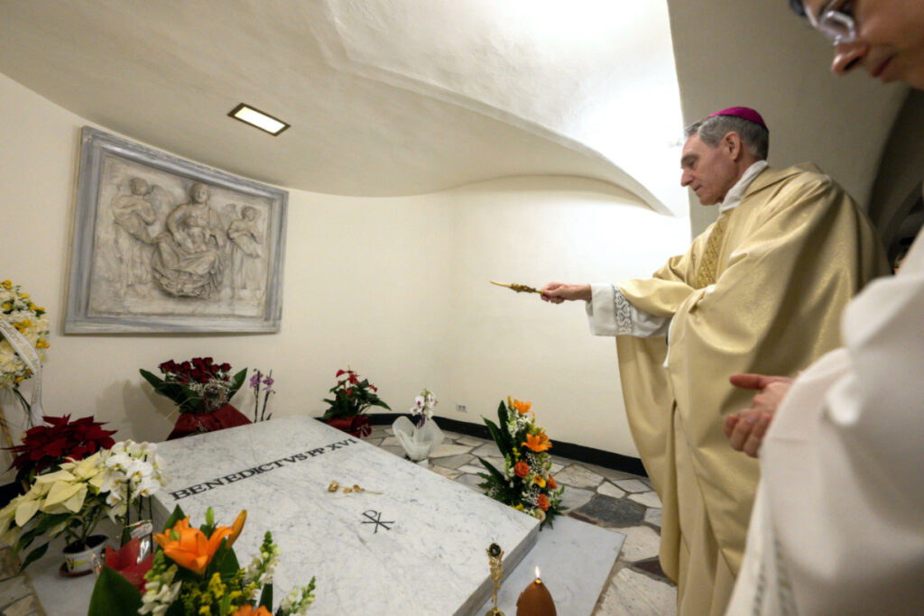 Former Pope Benedict's closest aide and private secretary, Archbishop Georg Ganswein, prays over the the tomb of Pope Emeritus in St Peter's Basilica, at the Vatican, on 31st December, 2023.